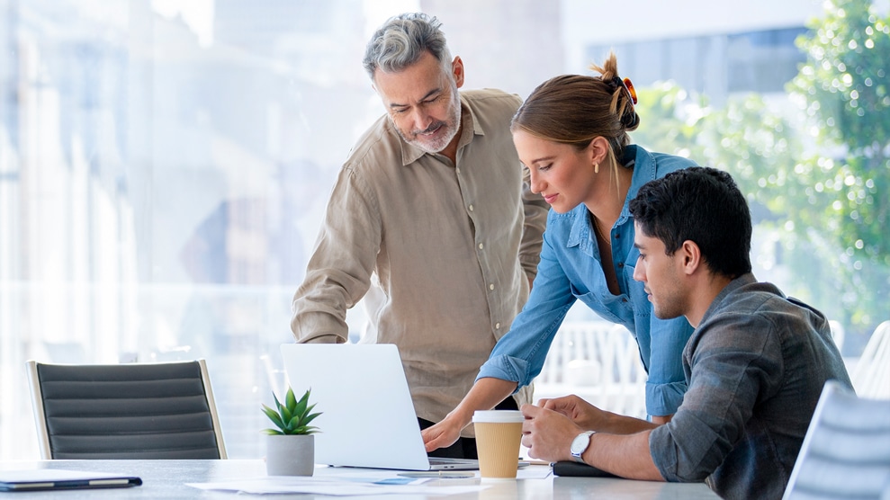 coworkers above laptop in office setting